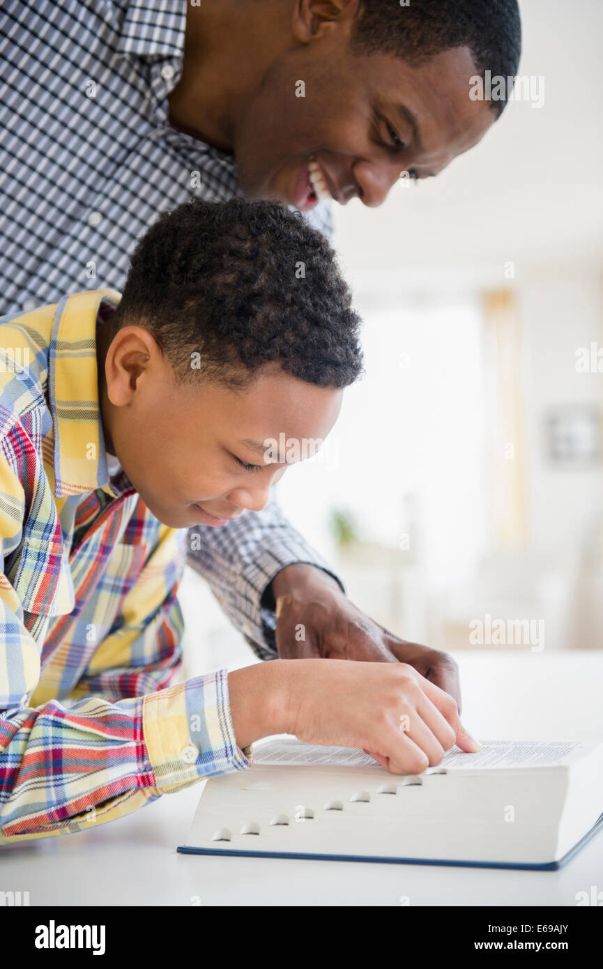 Father helping son dictionnaire de lecture Banque D'Images