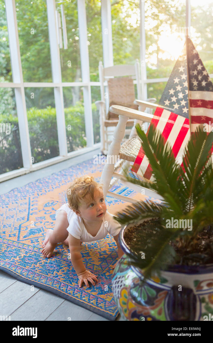 Caucasian baby crawling on porch Banque D'Images