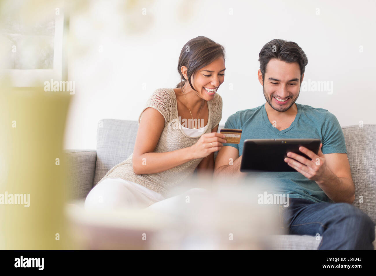 Couple shopping together on digital tablet Banque D'Images