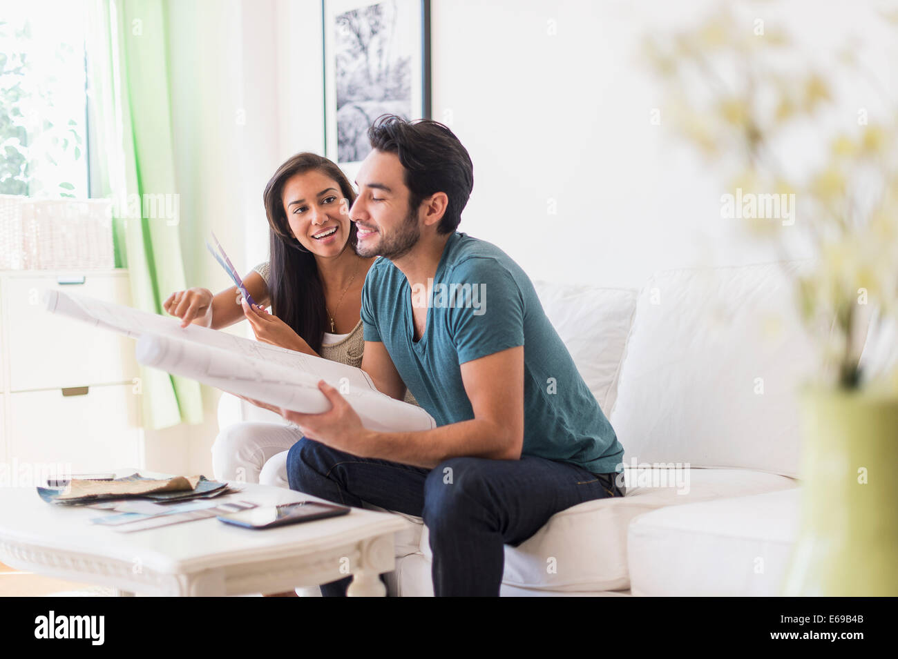 Couple examining blueprints in living room Banque D'Images
