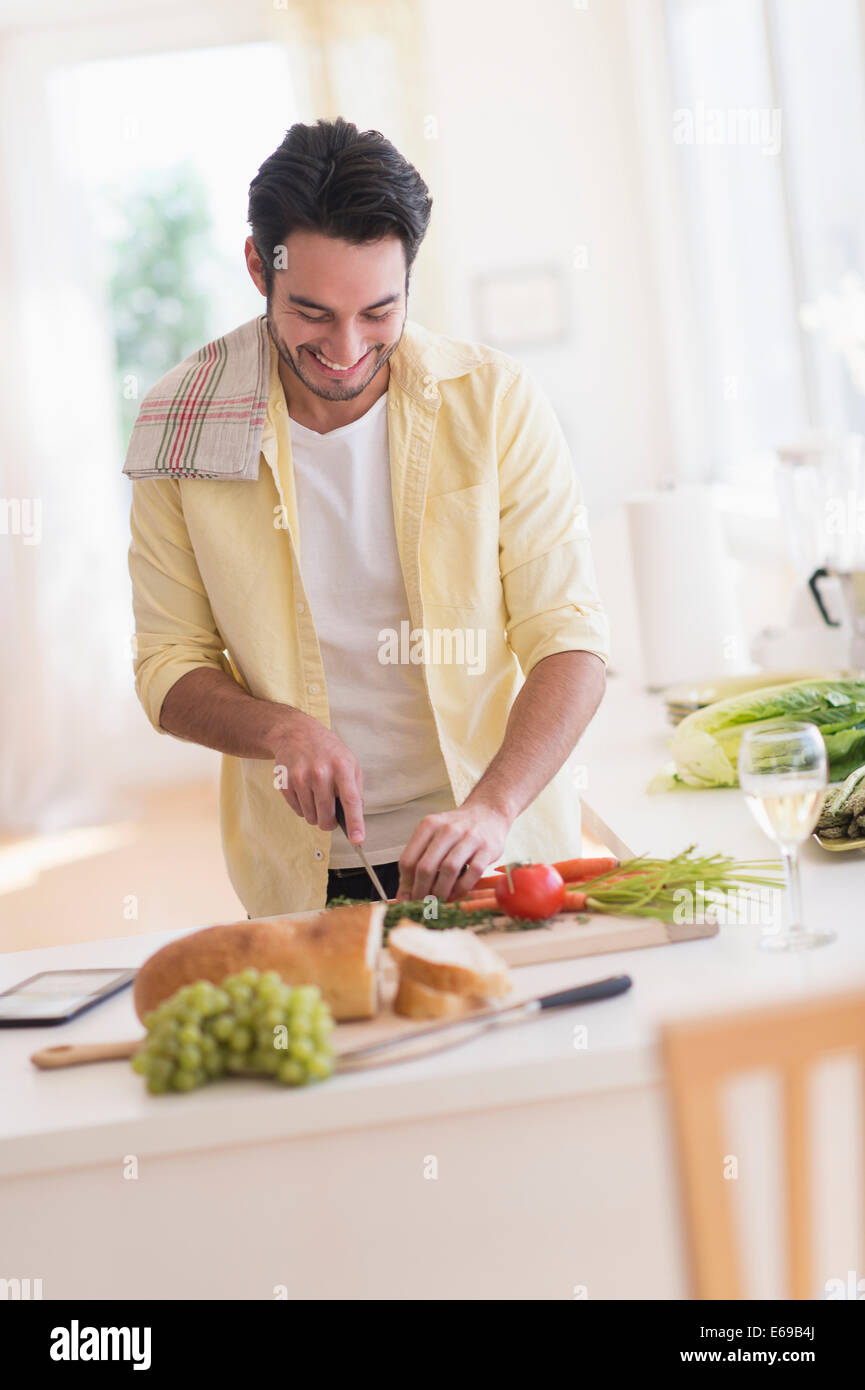 Mixed Race man cooking in kitchen Banque D'Images