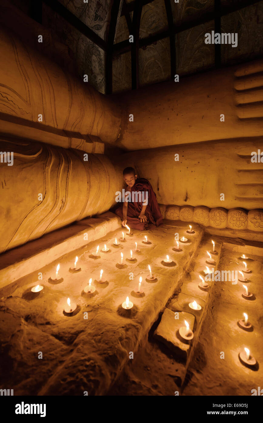 En allumant des bougies moine asiatique temple Banque D'Images