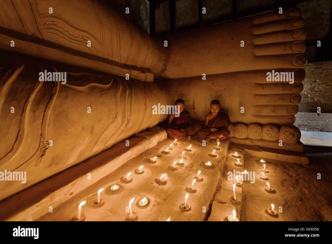 Les moines d'Asie temple en allumant des bougies Banque D'Images