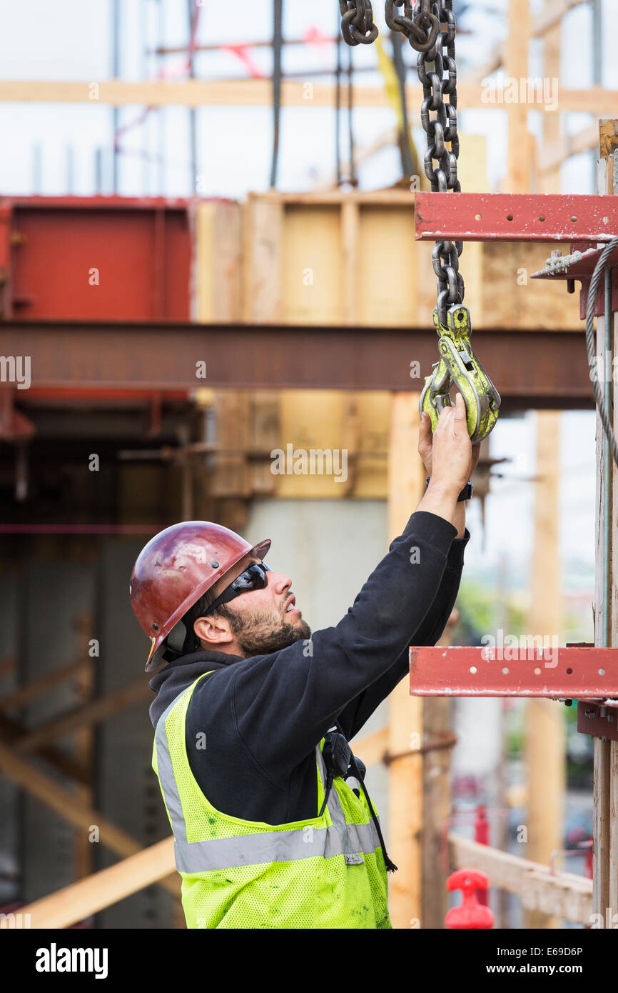 Caucasian worker holding hook at construction site Banque D'Images