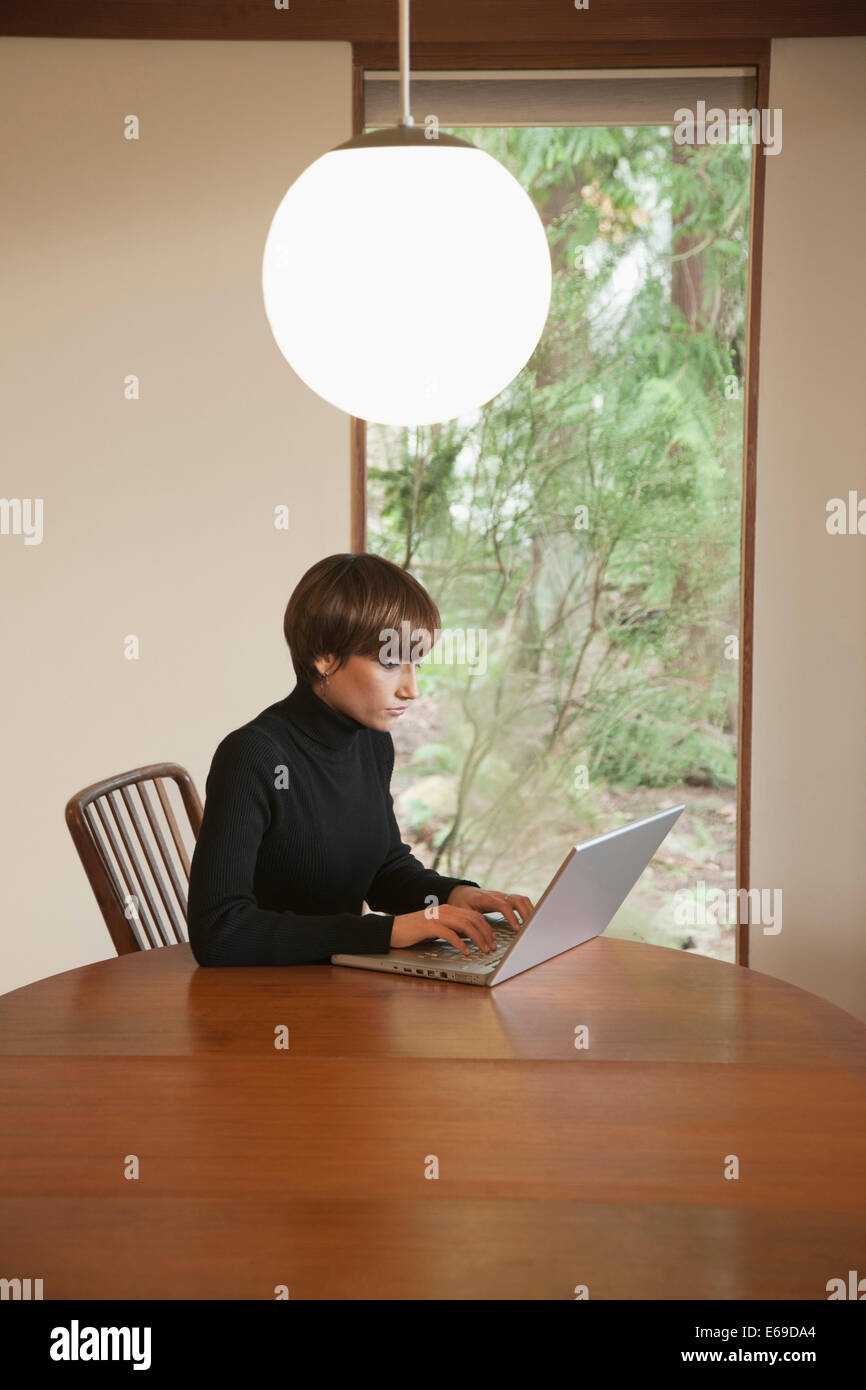 Caucasian woman using laptop on table Banque D'Images
