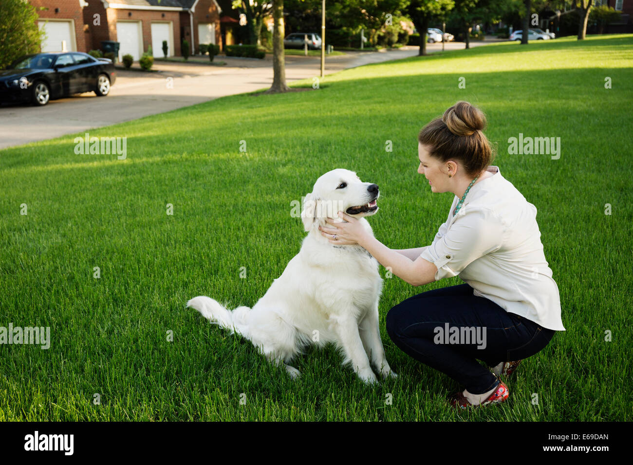 Caucasian woman petting dog in park Banque D'Images