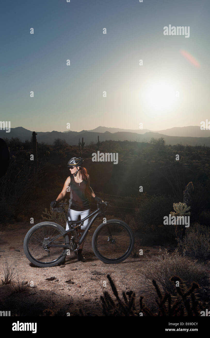 Mountain biker standing in desert Banque D'Images