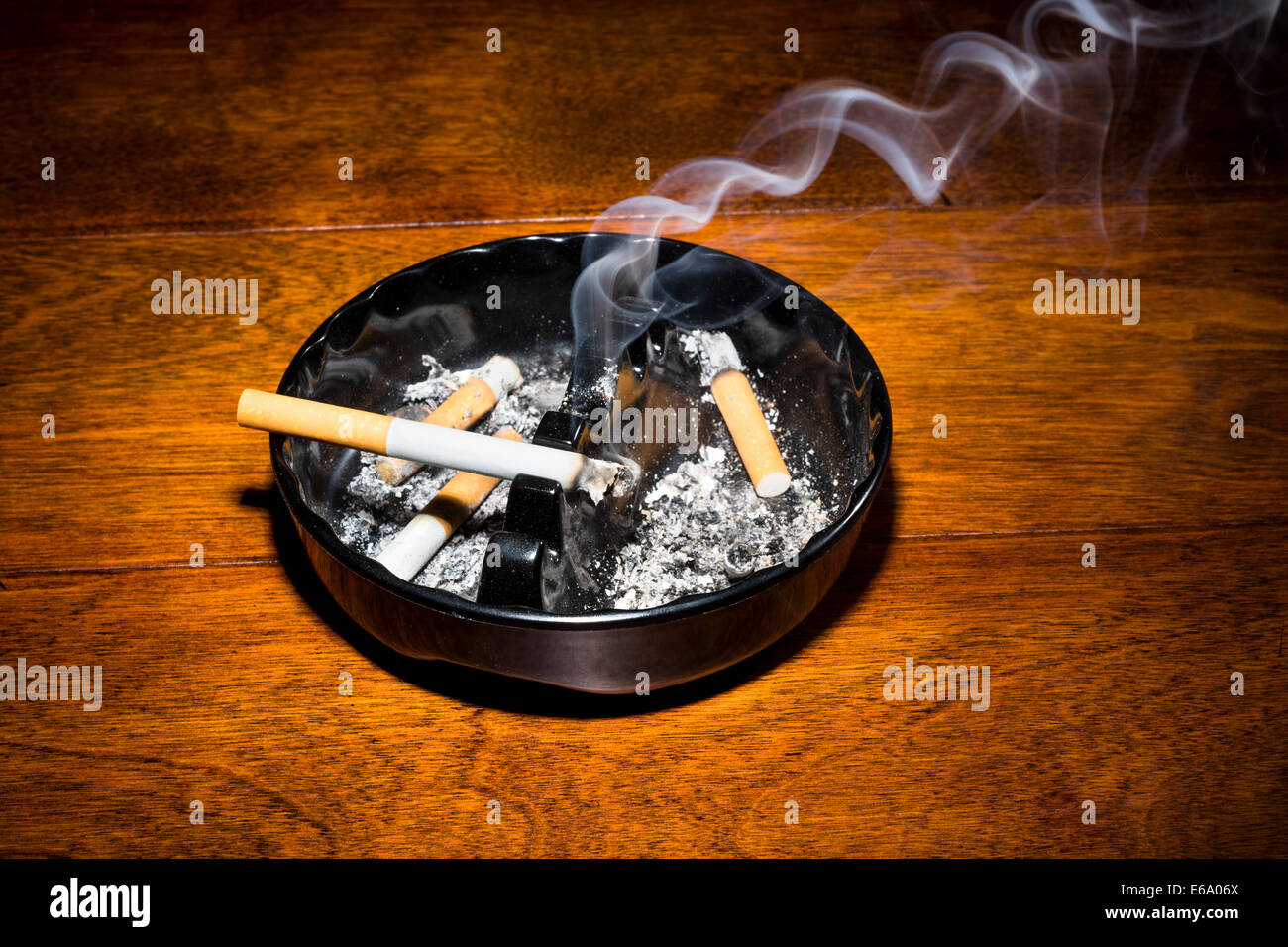 Un cigare dans un cendrier classique noir streaming fumeurs dans un endroit sombre, Moody. Banque D'Images