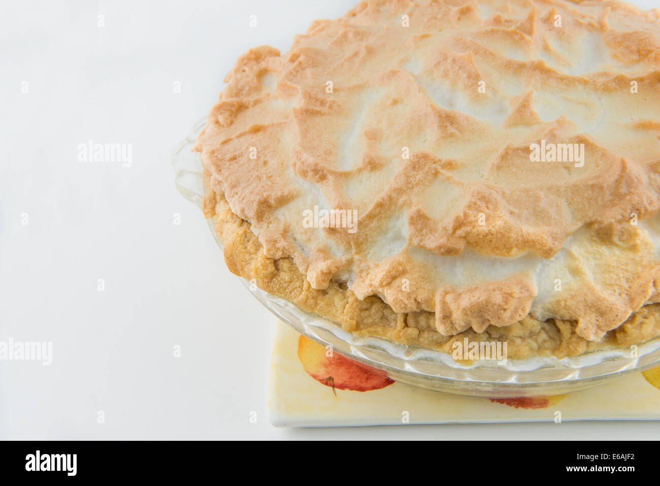 Un ensemble composé de meringue chocolat cream pie assis sur un trivit, fond blanc. USA Banque D'Images