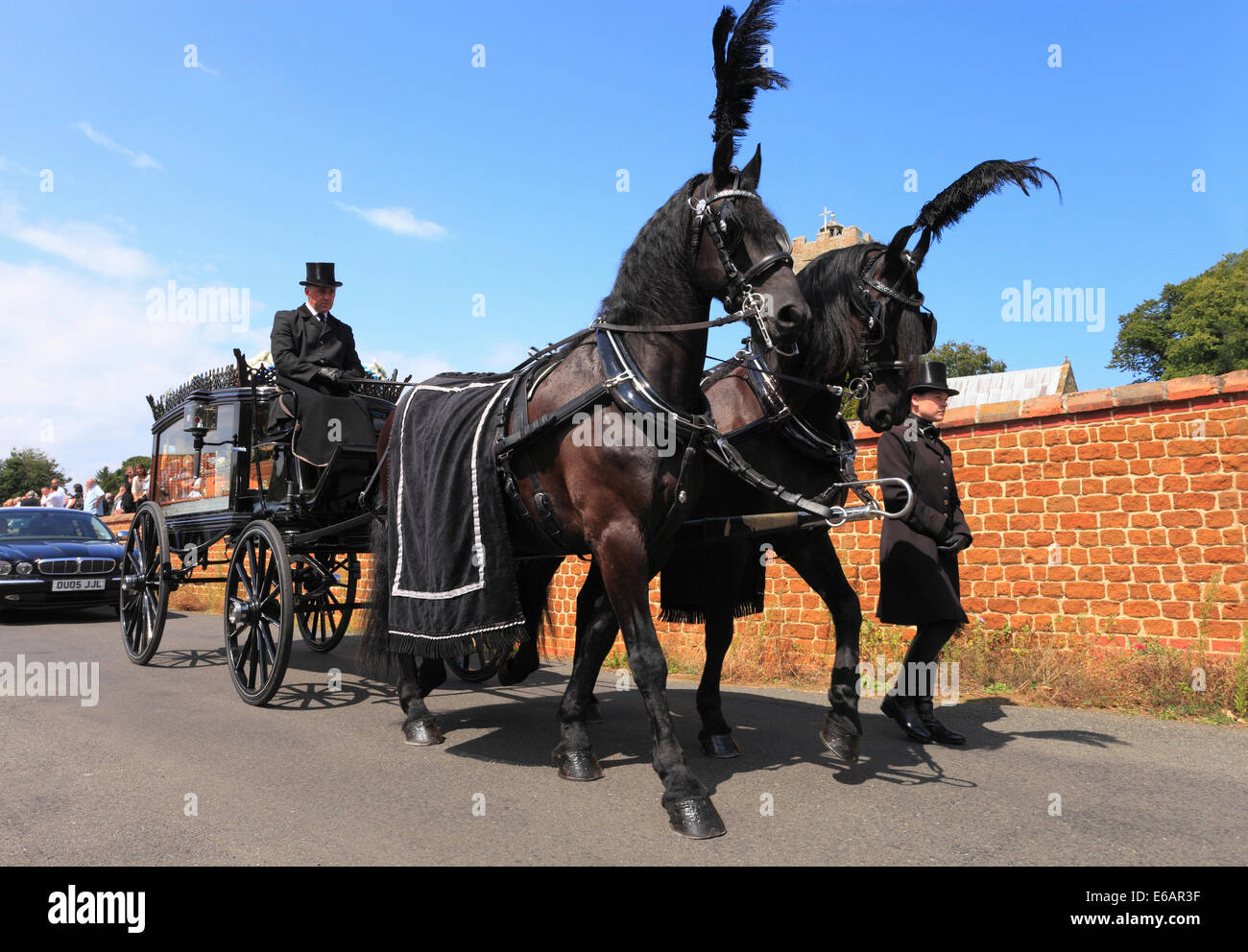 Corbillard tiré par des chevaux s'éloigner après un service funèbre. Banque D'Images