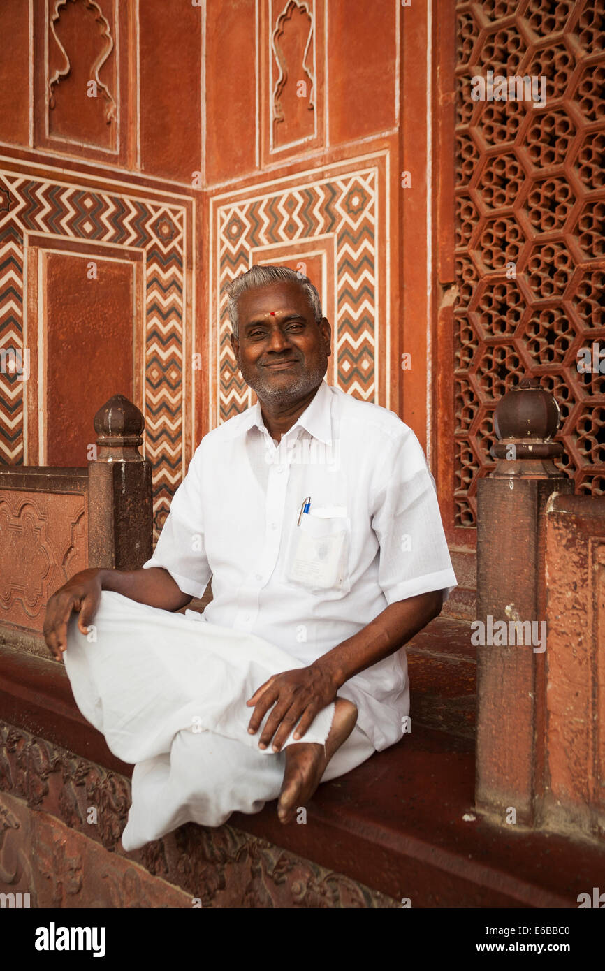 L'Inde, le Taj Mahal. Un Indien l'homme assis à la porte Royale, une entrée principale pour les visiteurs. Banque D'Images