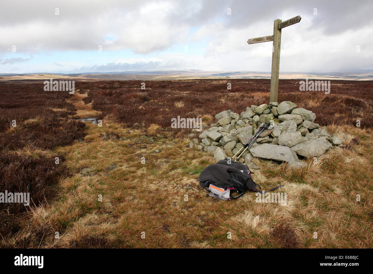 Cairn, sac à dos, bâtons de randonnée et Pennine Way fingerpost sur Deer jouer dans le Parc National de Northumberland, England, UK Banque D'Images