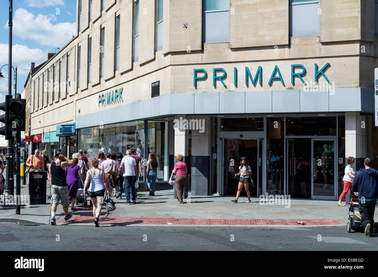 Traverser la route à l'extérieur les acheteurs de Primark dans le centre-ville de Cheltenham Banque D'Images