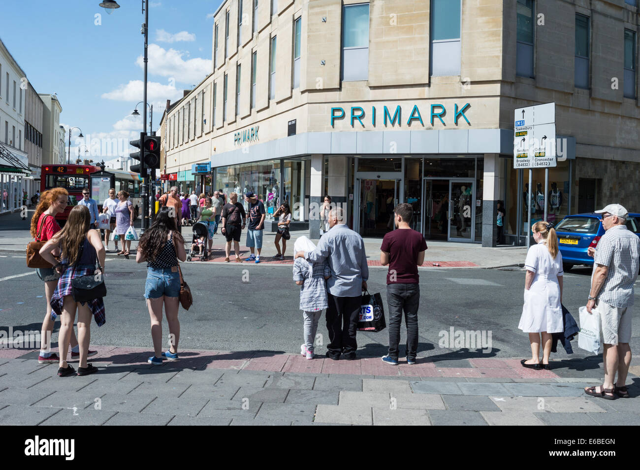 Traverser la route à l'extérieur les acheteurs de Primark dans le centre-ville de Cheltenham Banque D'Images