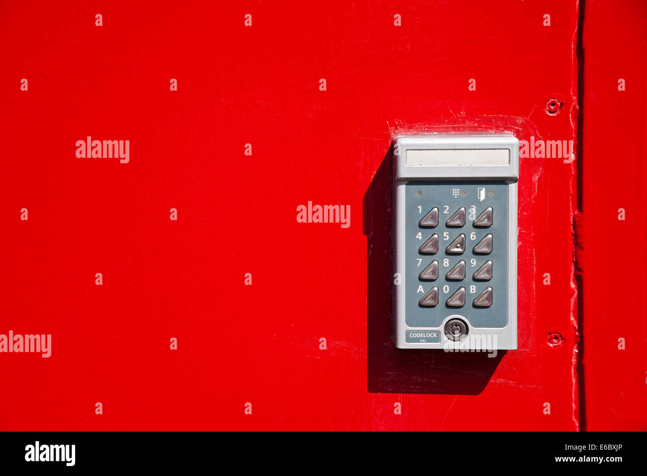 Gros plan de la porte en métal rouge vif avec combinaison électronique Entrée clavier verrouillage Angleterre Royaume-Uni Royaume-Uni Grande Grande-Bretagne Banque D'Images