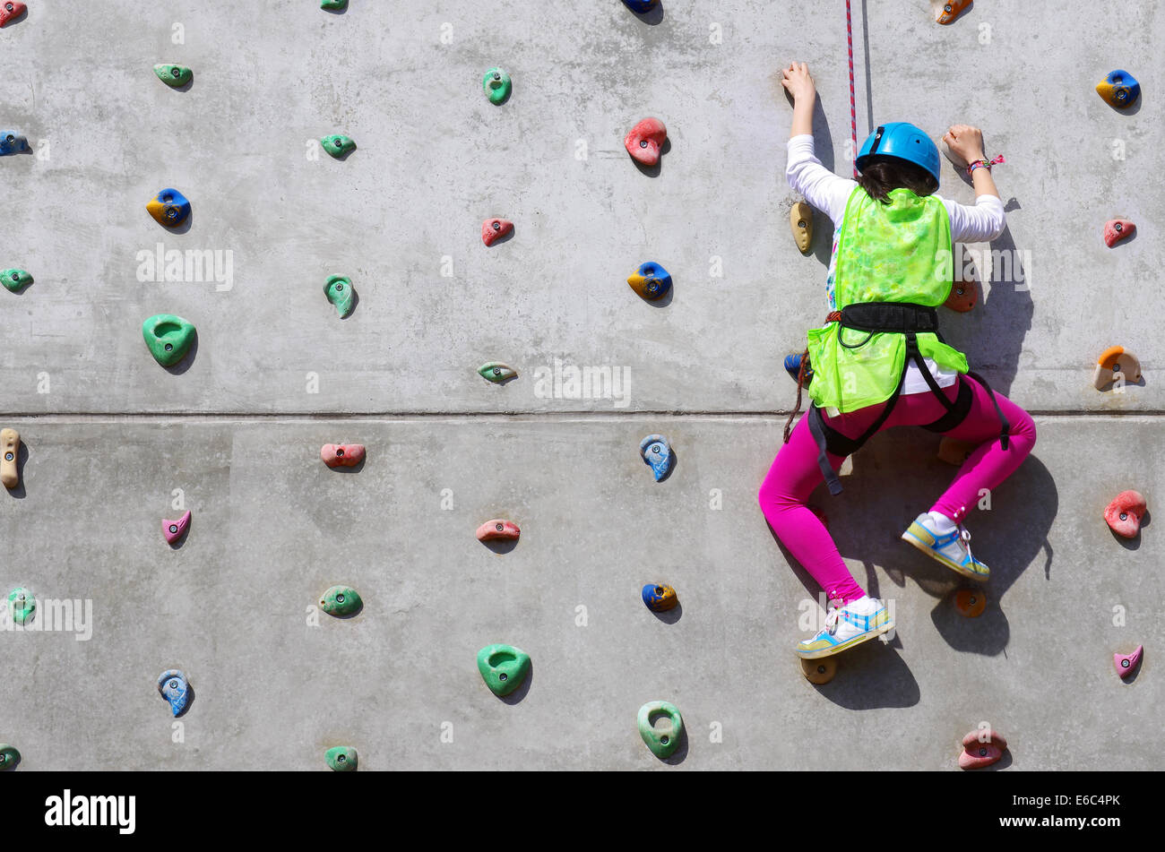 L'effort du jeune dans un mur d'escalade pour atteindre le sommet Banque D'Images