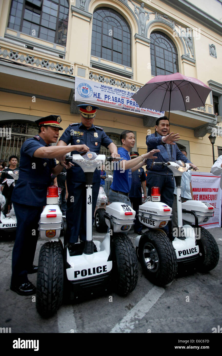 Manille, Philippines. 20e Août, 2014. Ancien président et actuel Maire de Manille, Joseph Estrada (1e R) rides un transporteur personnel électrique à l'Hôtel de ville de Manille à Manille, Philippines, 20 août 2014. Les véhicules électriques seront utilisées par des policiers pour une visibilité accrue et une réponse rapide dans des sites touristiques à Manille. © Rouelle Umali/Xinhua/Alamy Live News Banque D'Images