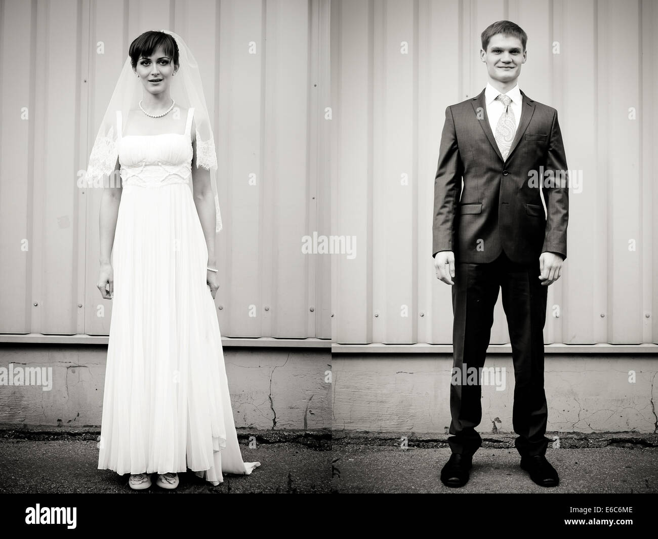 Full Length portrait of Bride and Groom standing against wall Banque D'Images