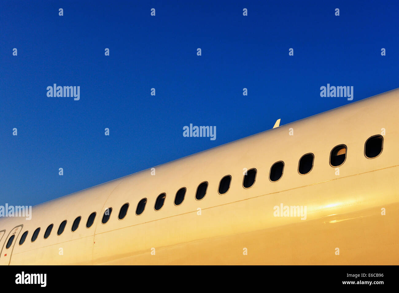 Airplane fuselage avec rangée de hublots au lever du soleil Banque D'Images