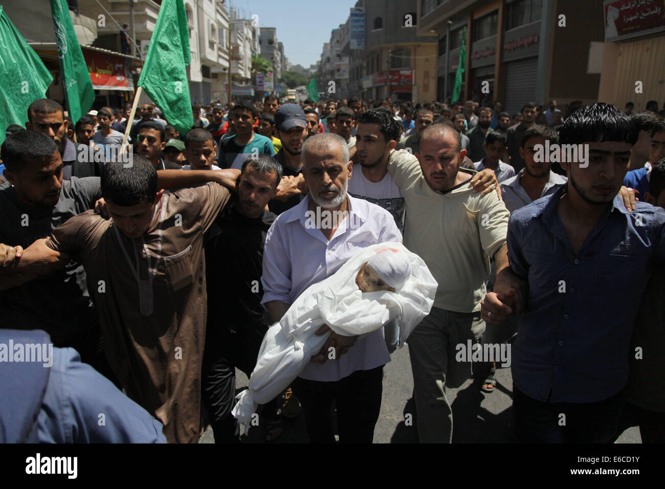 La ville de Gaza, bande de Gaza, territoire palestinien. 20e Août, 2014. Un parent de l'épouse d'un chef militaire du Hamas, Mohammed Deif, et son fils Ali, qui a déclaré que les infirmiers ont été tués dans des frappes aériennes israéliennes, transporte le corps d'Ali lors de leurs funérailles dans le nord de la bande de Gaza le 20 août 2014. Raids aériens israéliens ont tué 11 Palestiniens à Gaza, y compris l'épouse et son fils mineur de Deif, dans ce que le groupe a déclaré mercredi était une tentative de l'assassiner après un cessez-le-feu s'effondra. Credit : ZUMA Press, Inc./Alamy Live News Banque D'Images