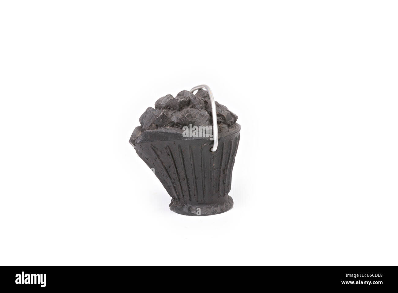 Morceau de charbon sculpté dans un seau à charbon miniature isolé sur fond blanc Banque D'Images
