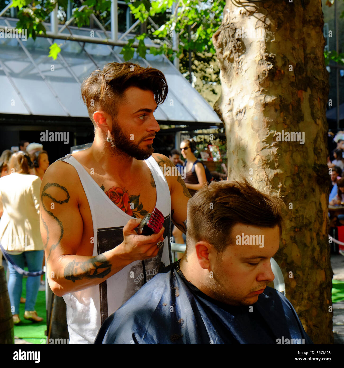 Couper les cheveux en plein air sur Brick Lane, Shoreditch, London Banque D'Images