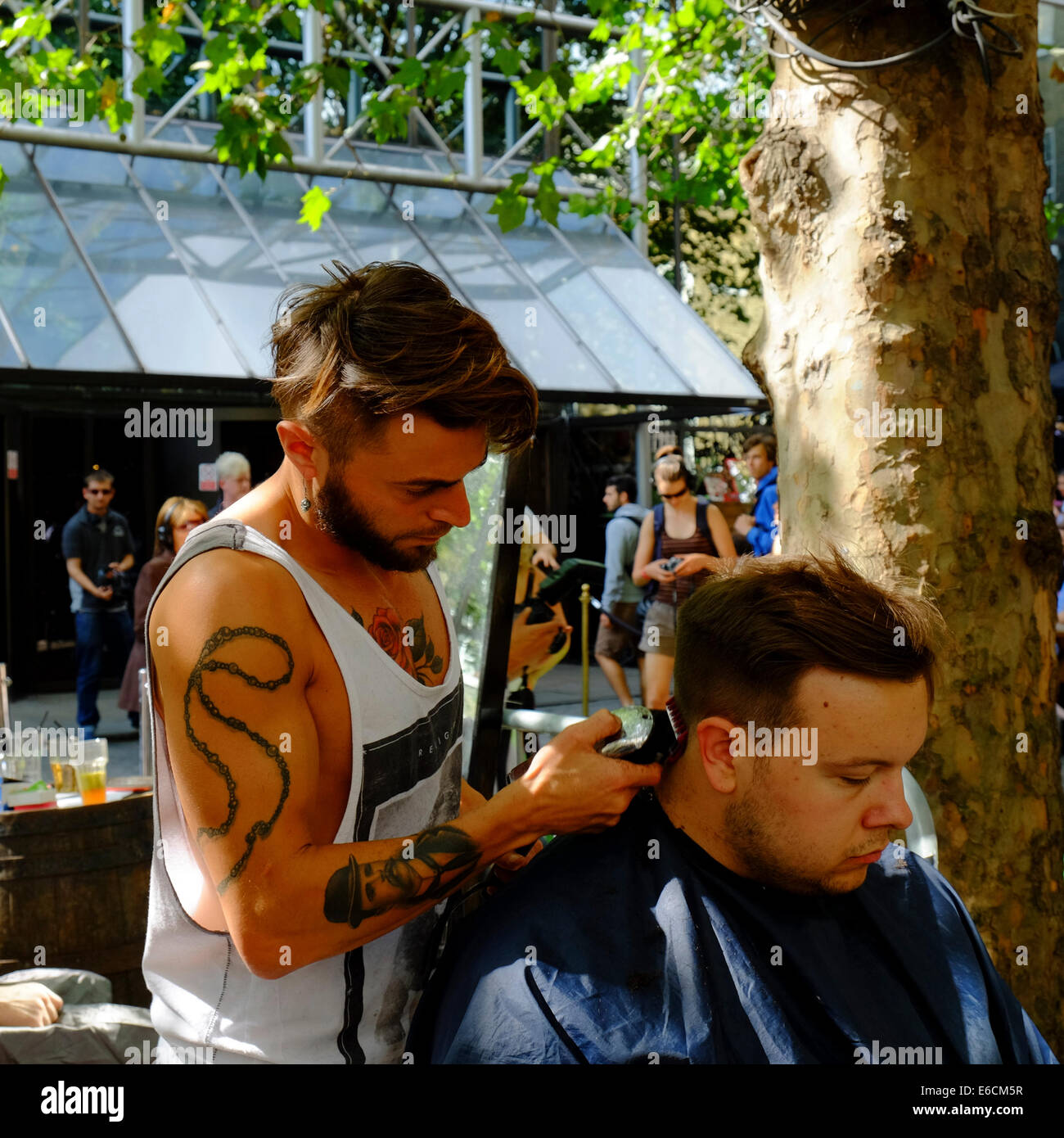Couper les cheveux en plein air sur Brick Lane, Shoreditch, London Banque D'Images