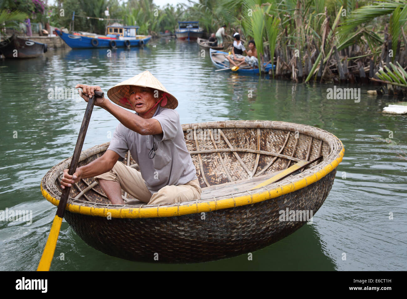 L'homme vietnamiens dans la hat Non bateau en bambou d'aviron à Hoa un Vietnam Banque D'Images