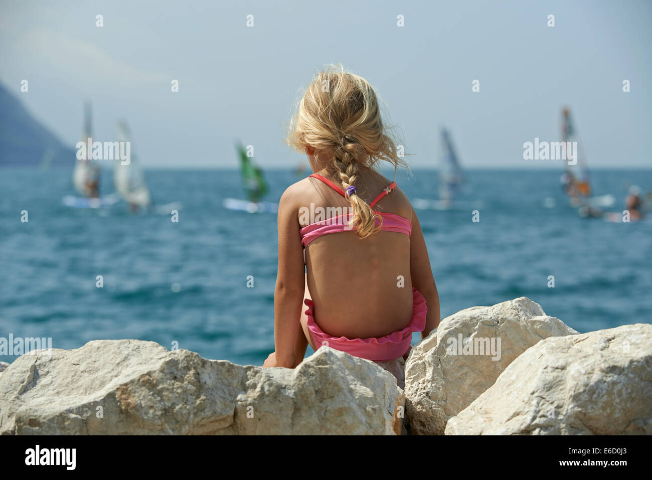 La fille blonde se penche sur des planches sur le lac de Garde près de Torbole, Lago di Garda, Torbole, Nago, Italie, Europe, alpes Banque D'Images