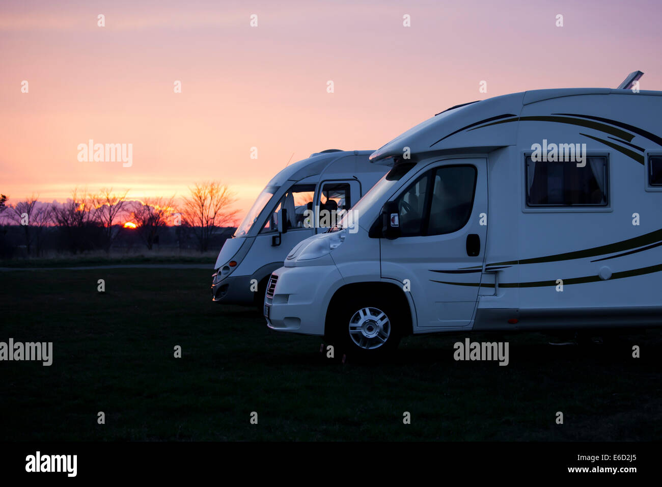 Deux voitures de camping modernes dans le coucher du soleil la lumière. Banque D'Images