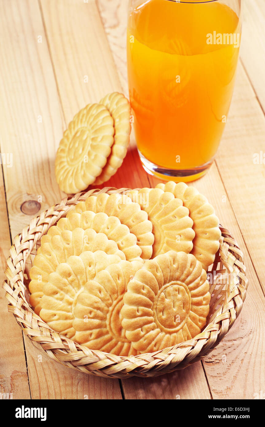 Sweet cookies et le verre de jus sur fond de bois Banque D'Images
