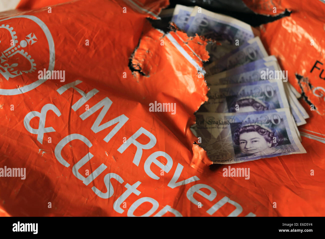 HM Revenue & Customs, Her Majesty's Revenue and Customs, déchiré et déchiré de l'paquet orange avec HMRC £20 notes Banque D'Images