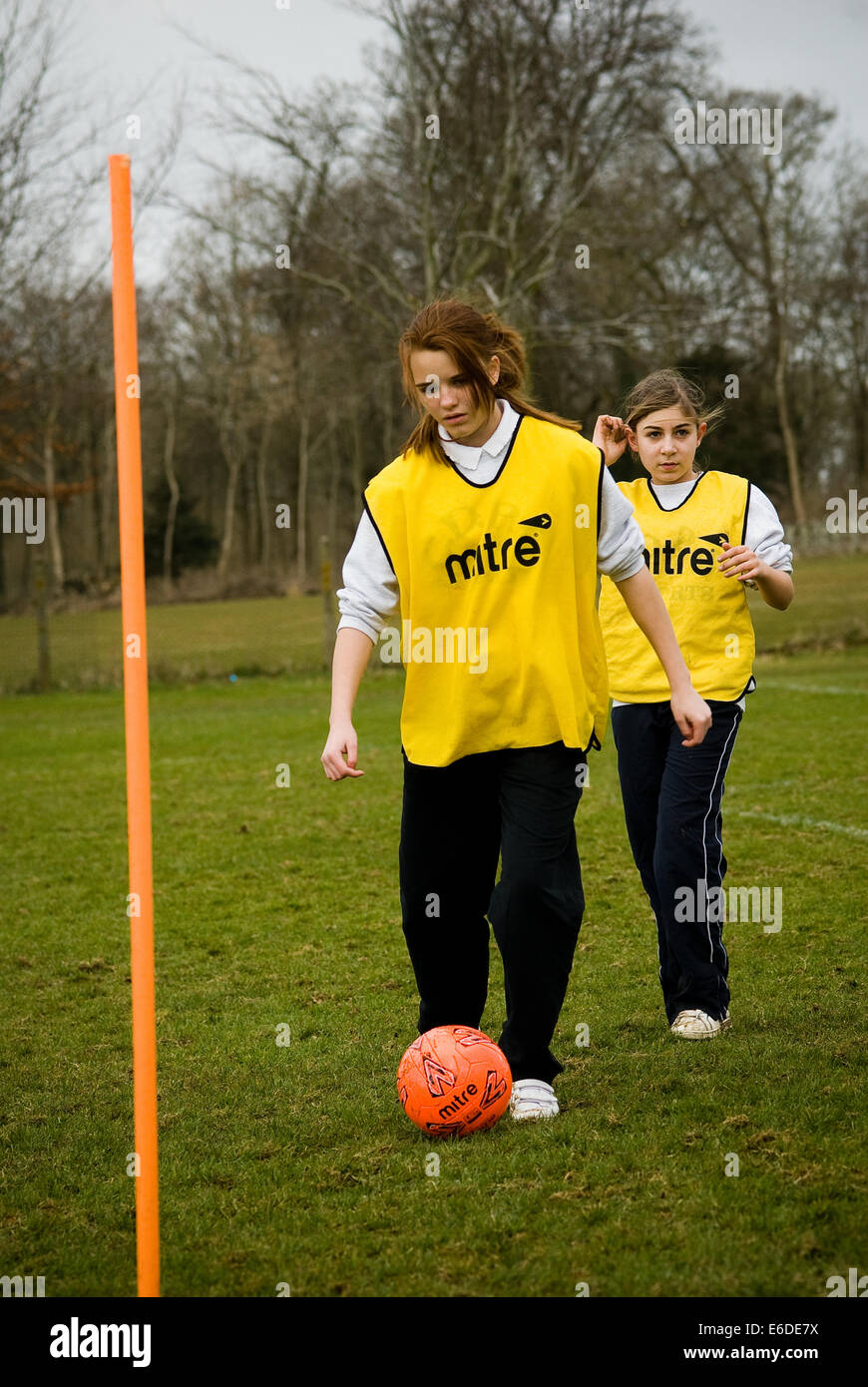 Fille jouant au football à l'école secondaire à Cirencester, Royaume-Uni Banque D'Images