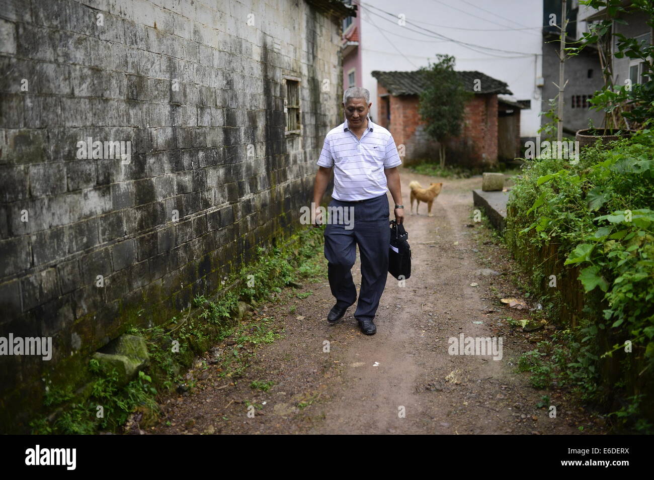 (140821) -- NANCHANG, 21 août 2014 (Xinhua) -- Jiang Changgen marche sur un chemin dans un paysage de Dexing, ville du centre de la Chine la Province du Jiangxi, le 19 août 2014. Jiang Changgen, 52, un ophtalmologiste qui servent dans certaines zones rurales du centre de la Chine, est un passionné d'hélicoptère qui a travaillé sur un hélicoptère pour certains 2 ans. L'assemblé, copter powered 4.0-litre moteur V8, est de 4 mètres de long et pèse autant qu'une tonne. Il y a encore une façon de prendre du sol Bien que Jiang a surmonté beaucoup de difficultés pour son rêve. (Xinhua/Zhou Mi) (WF) Banque D'Images
