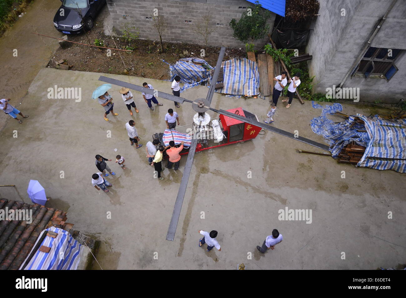 (140821) -- NANCHANG, 21 août 2014 (Xinhua) -- Jiang Changgen travaille sur un hélicoptère avec l'aide de villageois dans la cour d'une campagne dans le centre de la Chine, Ville Dexing, province de Jiangxi, 20 août 2014. Jiang Changgen, 52, un ophtalmologiste qui servent dans certaines zones rurales du centre de la Chine, est un passionné d'hélicoptère qui a travaillé sur un hélicoptère pour certains 2 ans. L'assemblé, copter powered 4.0-litre moteur V8, est de 4 mètres de long et pèse autant qu'une tonne. Il y a encore une façon de prendre du sol Bien que Jiang a surmonté beaucoup de difficultés pour son rêve. Banque D'Images