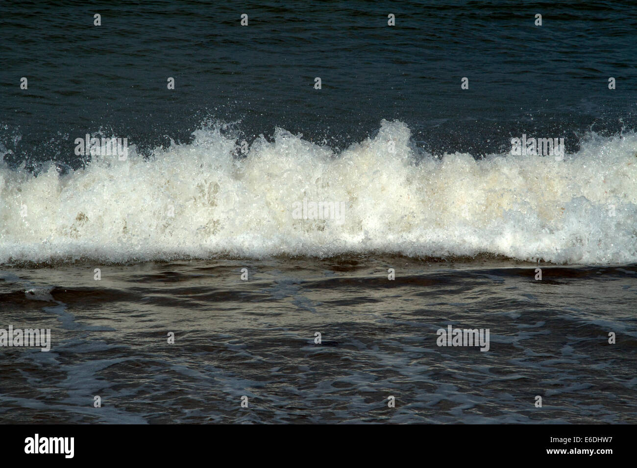 Une image de la mer représentant le surf entrant avec la mer à l'avant et à l'arrière. Sombre, Paynes gris mer au-dessus et en dessous de surf.Moody. Banque D'Images