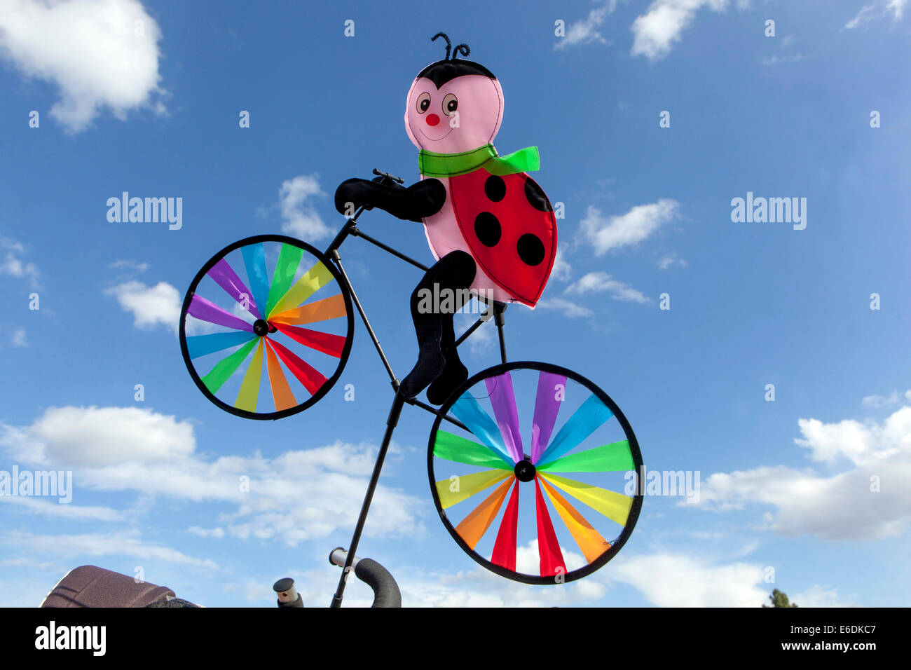 Coccinelle sur vélo décorée dans des couleurs LGBT, fond bleu ciel Banque D'Images