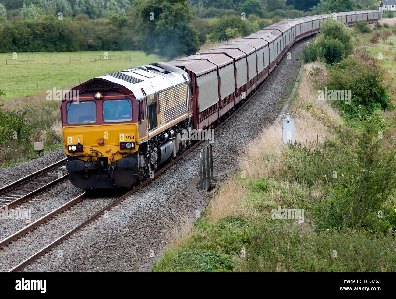 Un EWS class 66 traction diesel train un wagon vide, Northamptonshire, Angleterre Banque D'Images