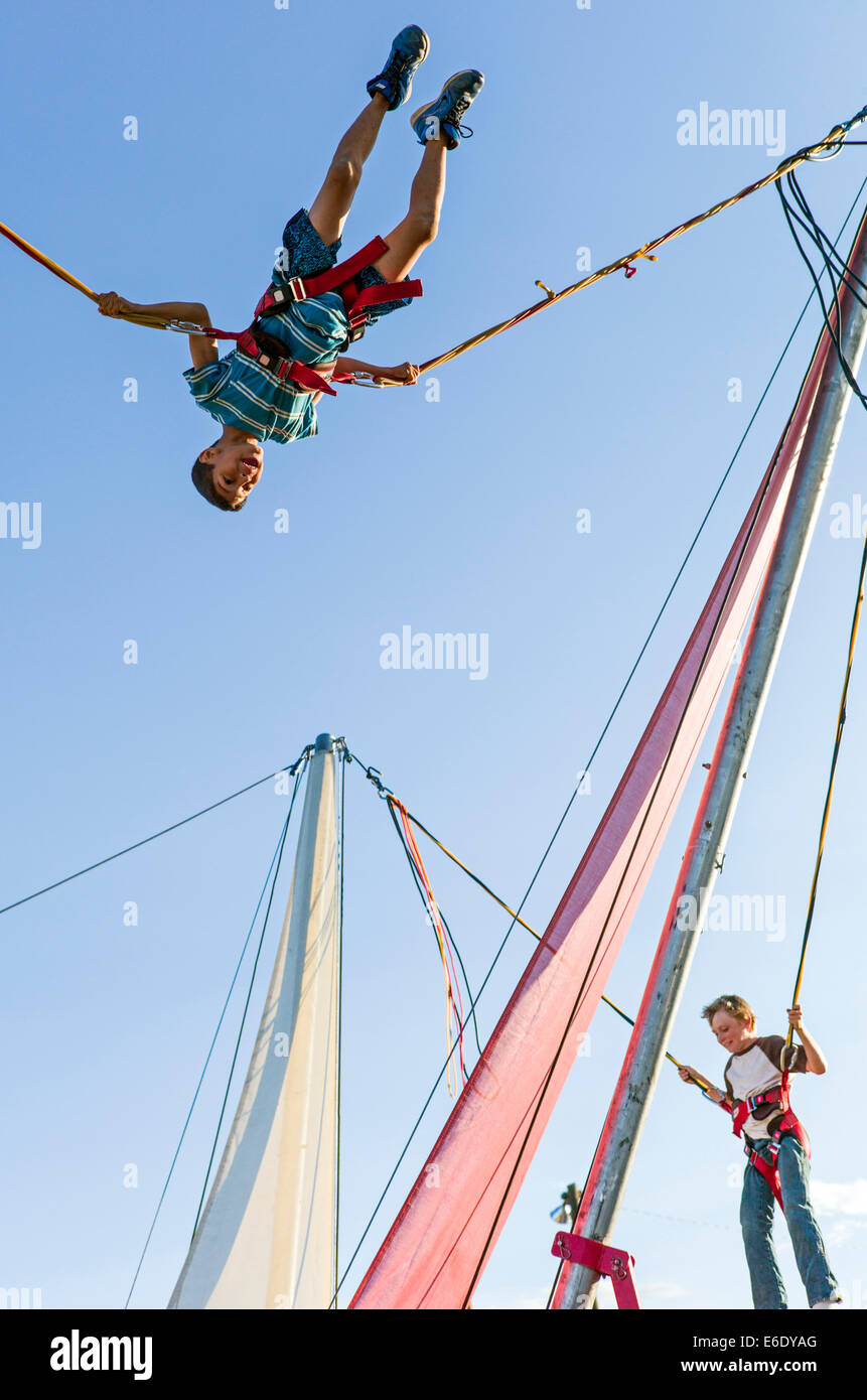 Les enfants de rebondir sur un trampoline Bungee, Chaffee County Fair, Colorado, USA Banque D'Images