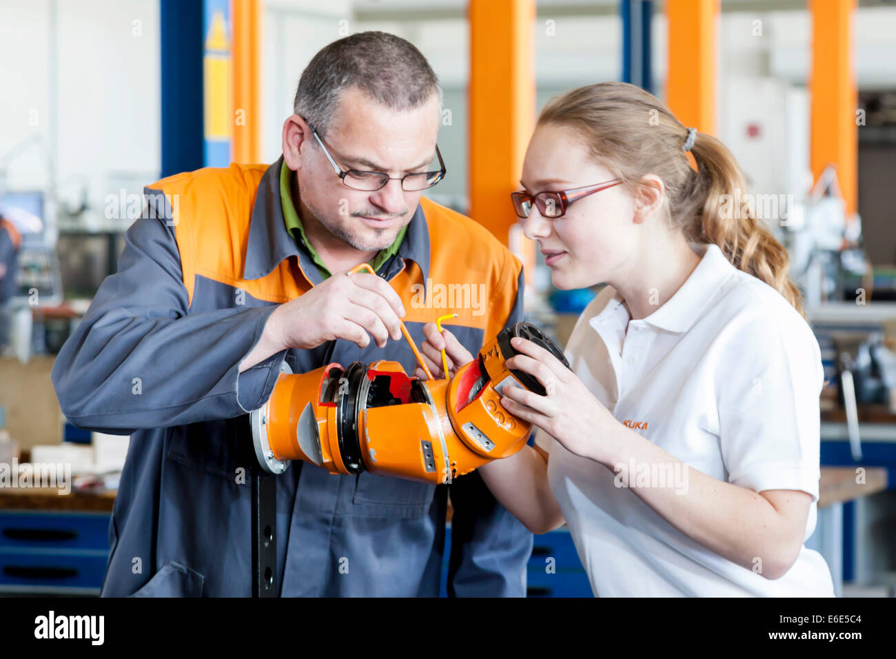 L'explication de l'instructeur un robot part à un stagiaire pour la mécatronique les travaux de montage, centre de formation de l'fabricant de robots KUKA Banque D'Images
