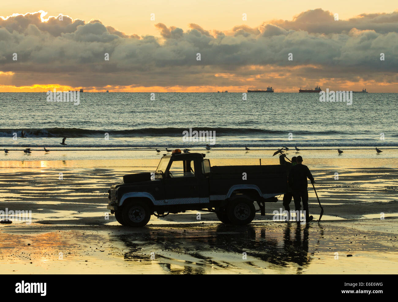 Seaton Carew près de Hartlepool, UK. 22 août, 2014. Météo : Seacoalers sur Seaton Carew beach juste après le lever du soleil. Une fois qu'un site commun le long de la côte nord-est avant la fermeture des mines, seule une poignée d'Seacoalers maintenant travailler les plages de Seaton et Hartlepool. Le charbon de mer échoués coutures vieille mine est chargé sur un camion pour être plus tard, nettoyés et vendus sur des centrales thermiques. Credit : ALANDAWSONPHOTOGRAPHY/Alamy Live News Banque D'Images