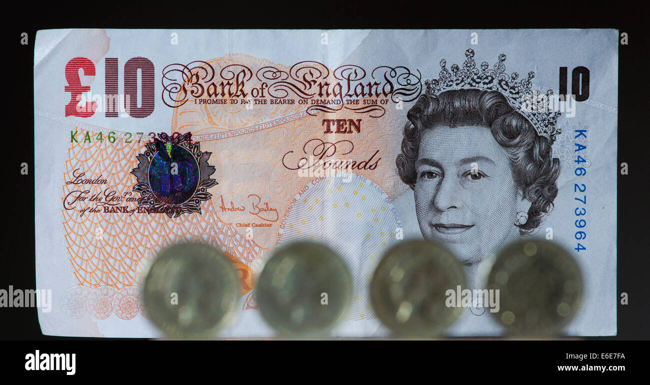 €1 pièces Stirling britanniques sont représentés à l'avant d'un £10 Stirling britannique note. Banque D'Images