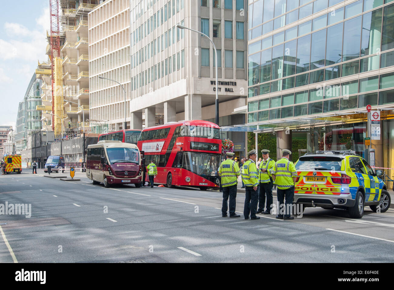 Londres, Royaume-Uni. 22 août, 2014. Des agents de la Police métropolitaine, à la suite d'un accident de la route dans lequel un piéton très ladened shopping a été frappé par un autobus sur la rue Victoria. Credit : Pete Maclaine/Alamy Live News Banque D'Images