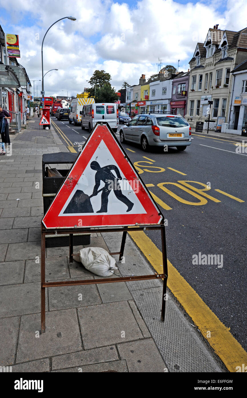 Brighton UK - l'homme au travail travaux street sign in road Banque D'Images