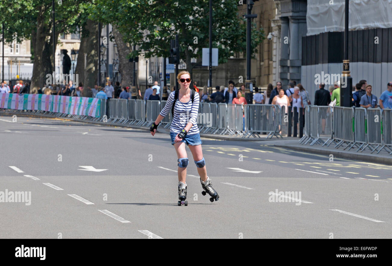 Londres, Angleterre, Royaume-Uni. Jeune femme rollers dans Whitehall tandis que le trafic est arrêté avant une course à vélo Banque D'Images