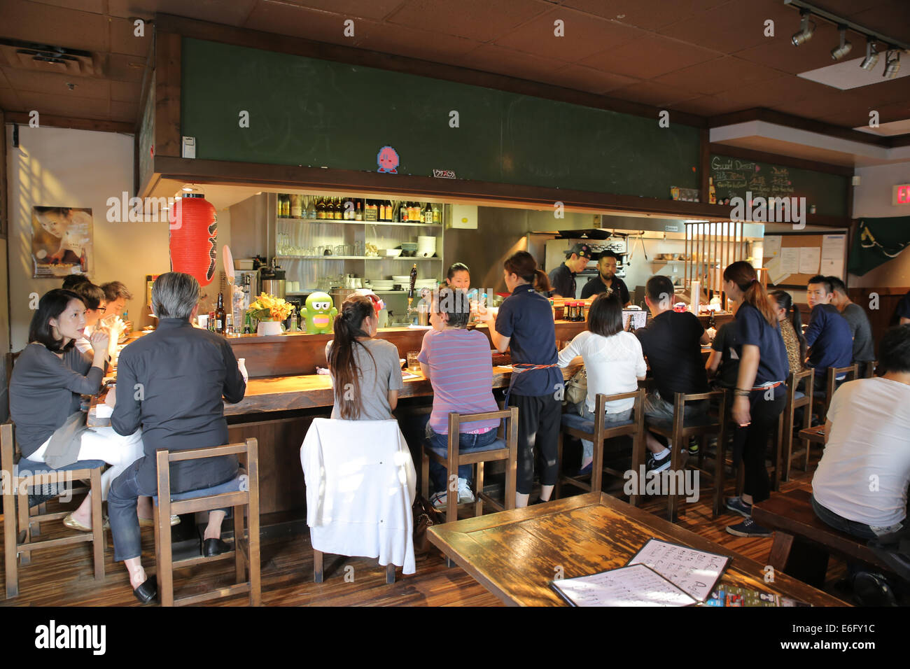 Les clients à l'intérieur de la plaque petit Izakaya japonais restaurant Vancouver Canada Banque D'Images