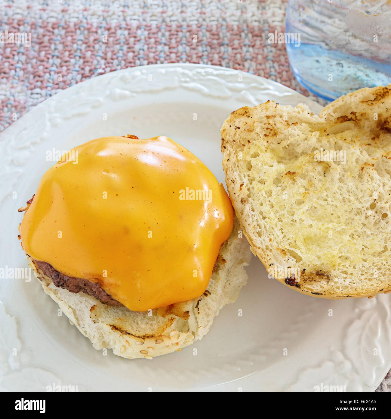 Délicieux hamburger fait maison avec du fromage à la table de la cuisine. Banque D'Images