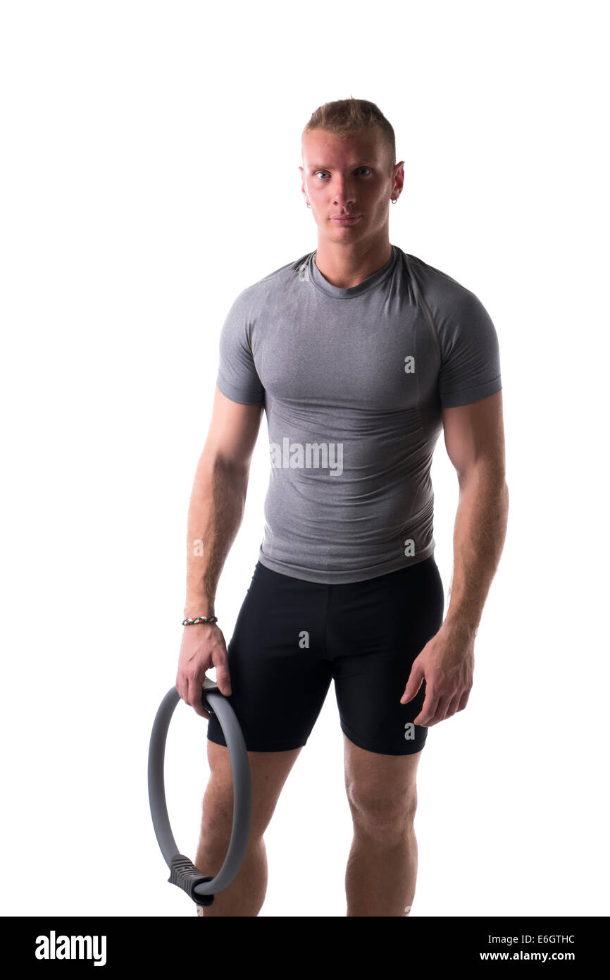 Jeune homme musclé détendu avec anneau Pilates en main, isolated on white Banque D'Images