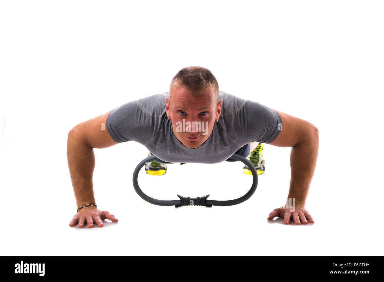Jeune homme musclé blonde exerçant sur le sol avec le Pilates ring isolated on white Banque D'Images
