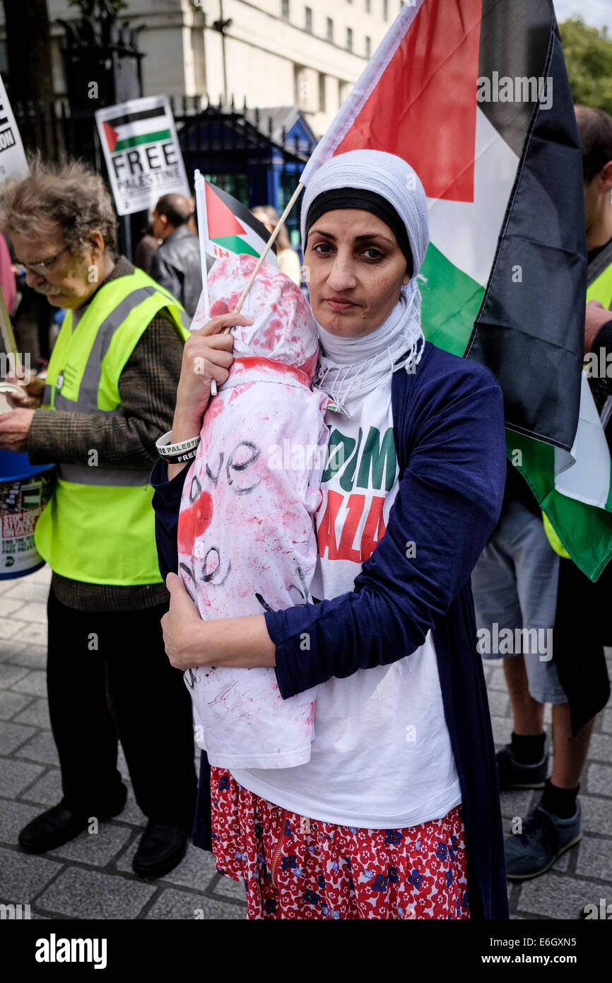 Londres, Royaume-Uni. 23 août, 2014. Un manifestant pro-palestinienne est titulaire d'une poupée tachée de sang qu'elle démontre à l'extérieur de Downing Street contre les ventes d'armes à Israël. Credit : Gordon 1928/Alamy Live News Banque D'Images